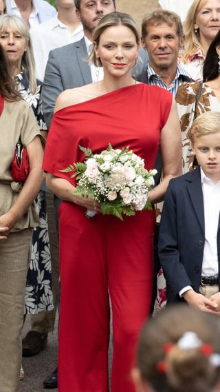 Princess Charlene of Monaco holding a bunch of flowers as she attends the Traditional Monaco annual picnic on September 07, 2024