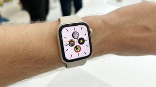 En vit Apple Watch SE 2 sitter runt en persons handled.