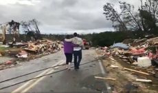 People look at tornado damage in Lee County, Alabama.