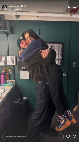 Tom Blyth lifts Rachel Zegler up in the air for a hug backstage of her musical Romeo + Juliet.