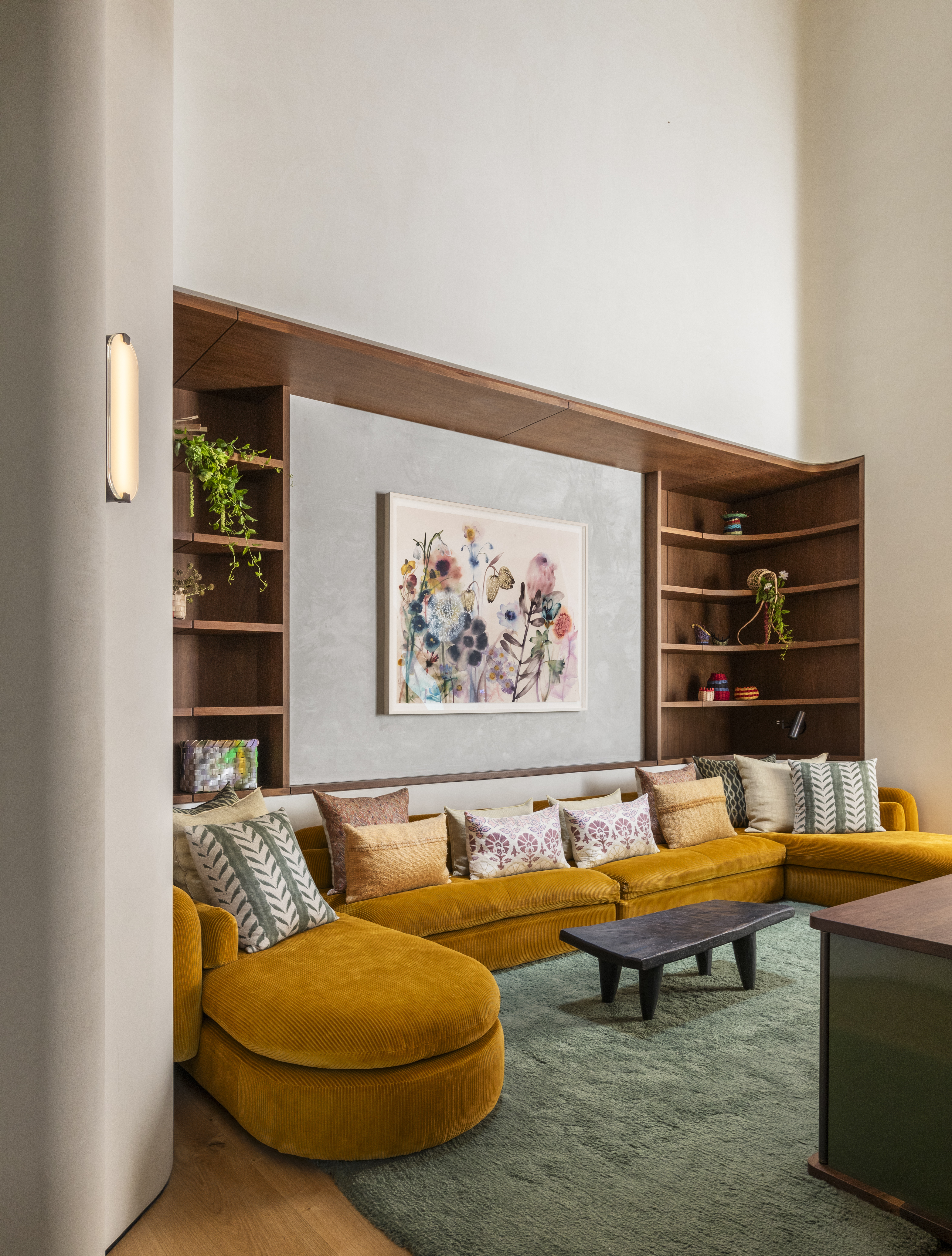 A mustard-colored couch atop a green rug