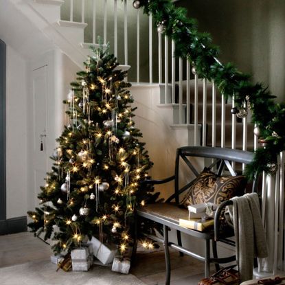 A christmas tree at the bottom of the stairs