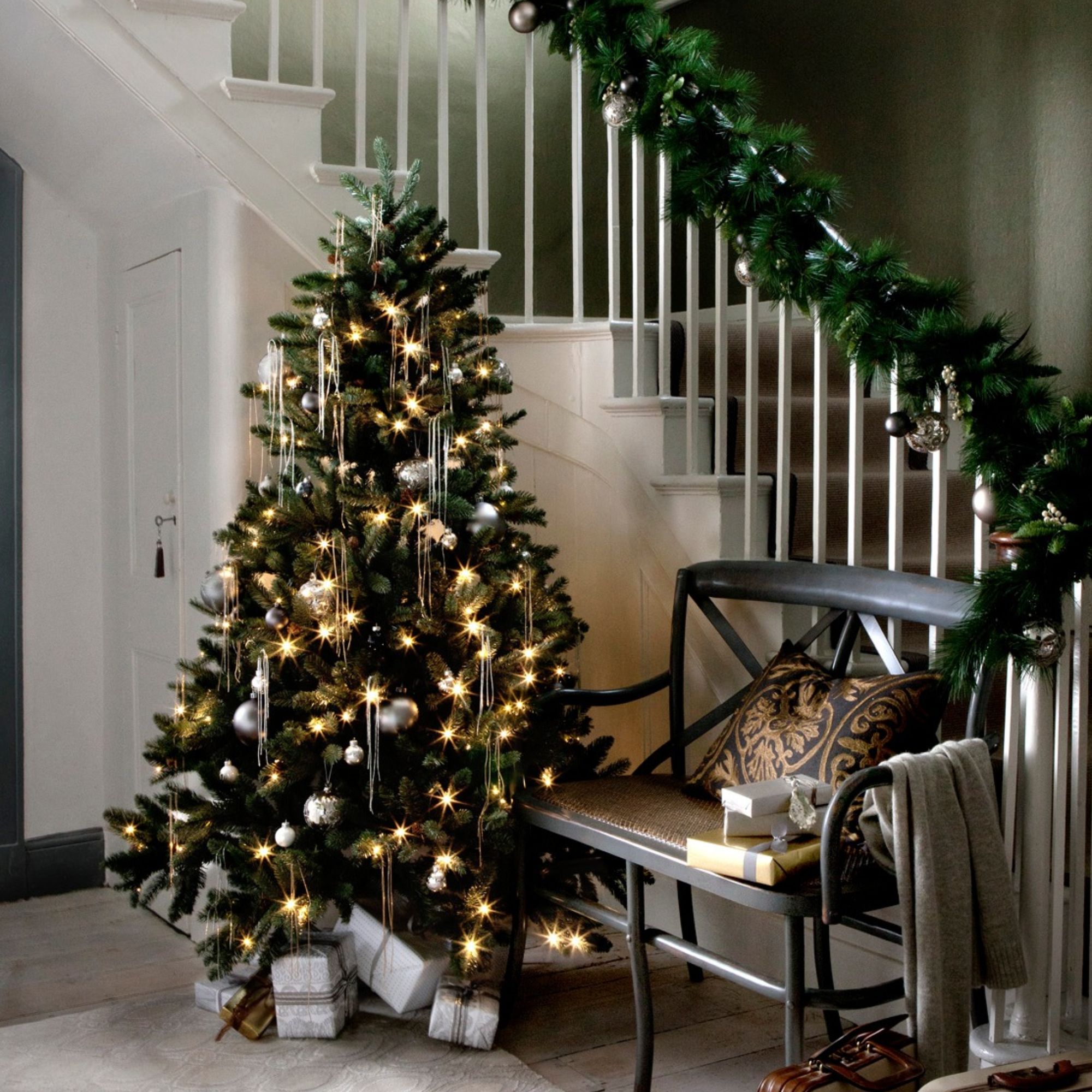 A christmas tree at the bottom of the stairs