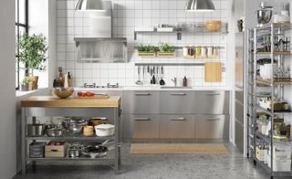 A stainless steel kitchen with small peninsula butcher's block, open shelving