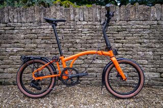 Orange Brompton G Line stood by wall, side on