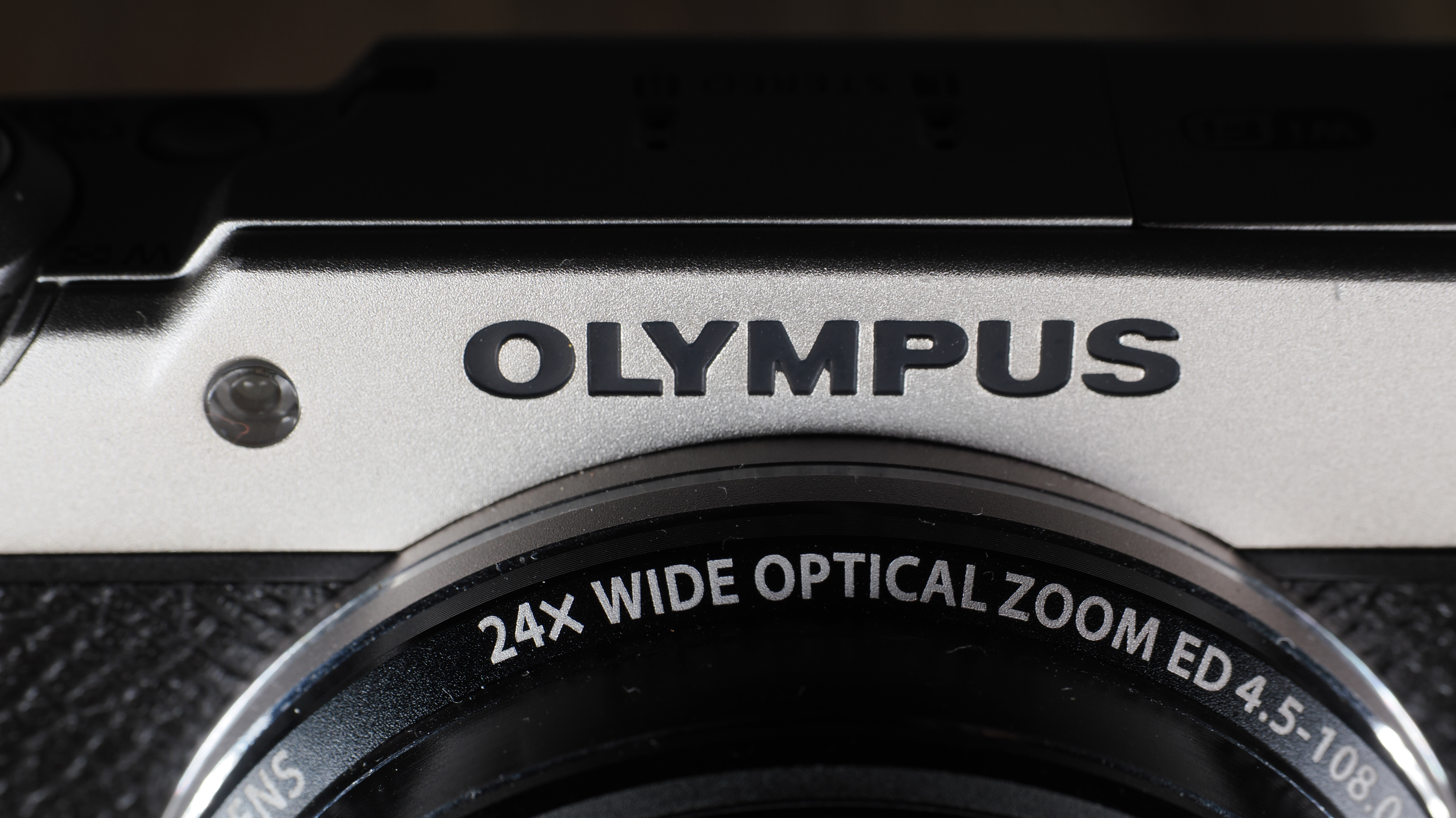 Olympus Stylus SH-3 on a wooden surface