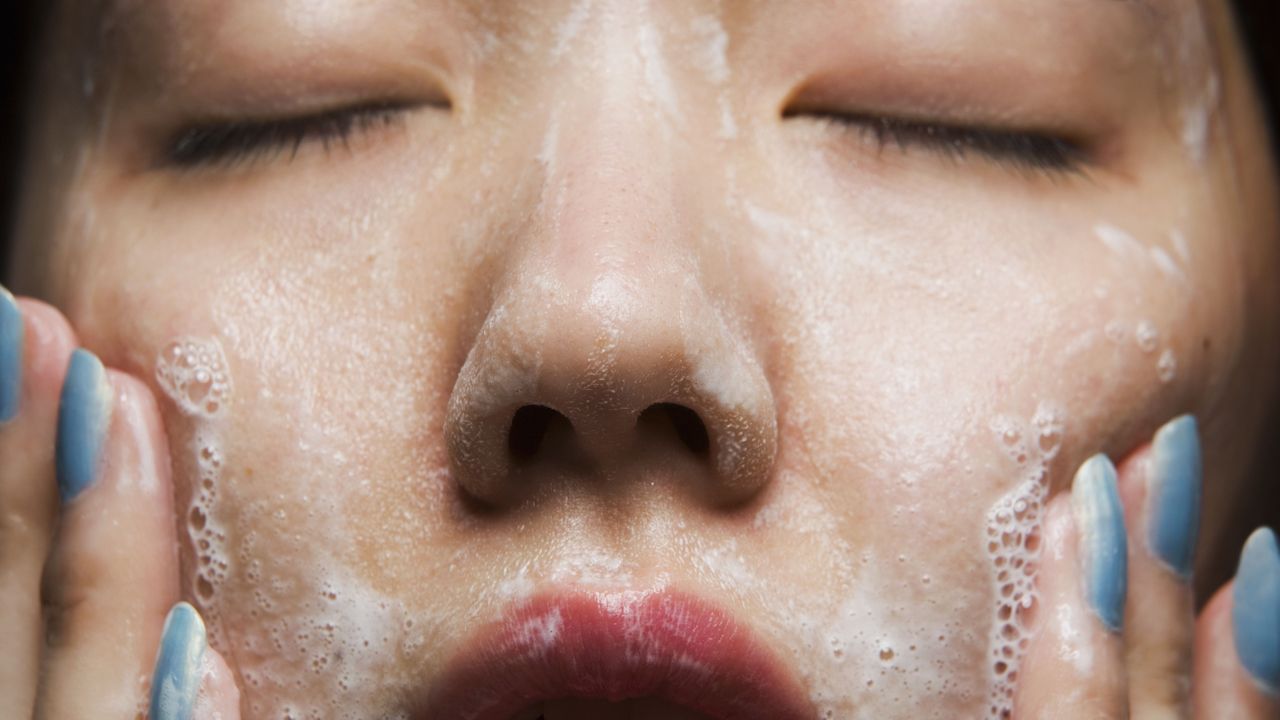 young woman washing face