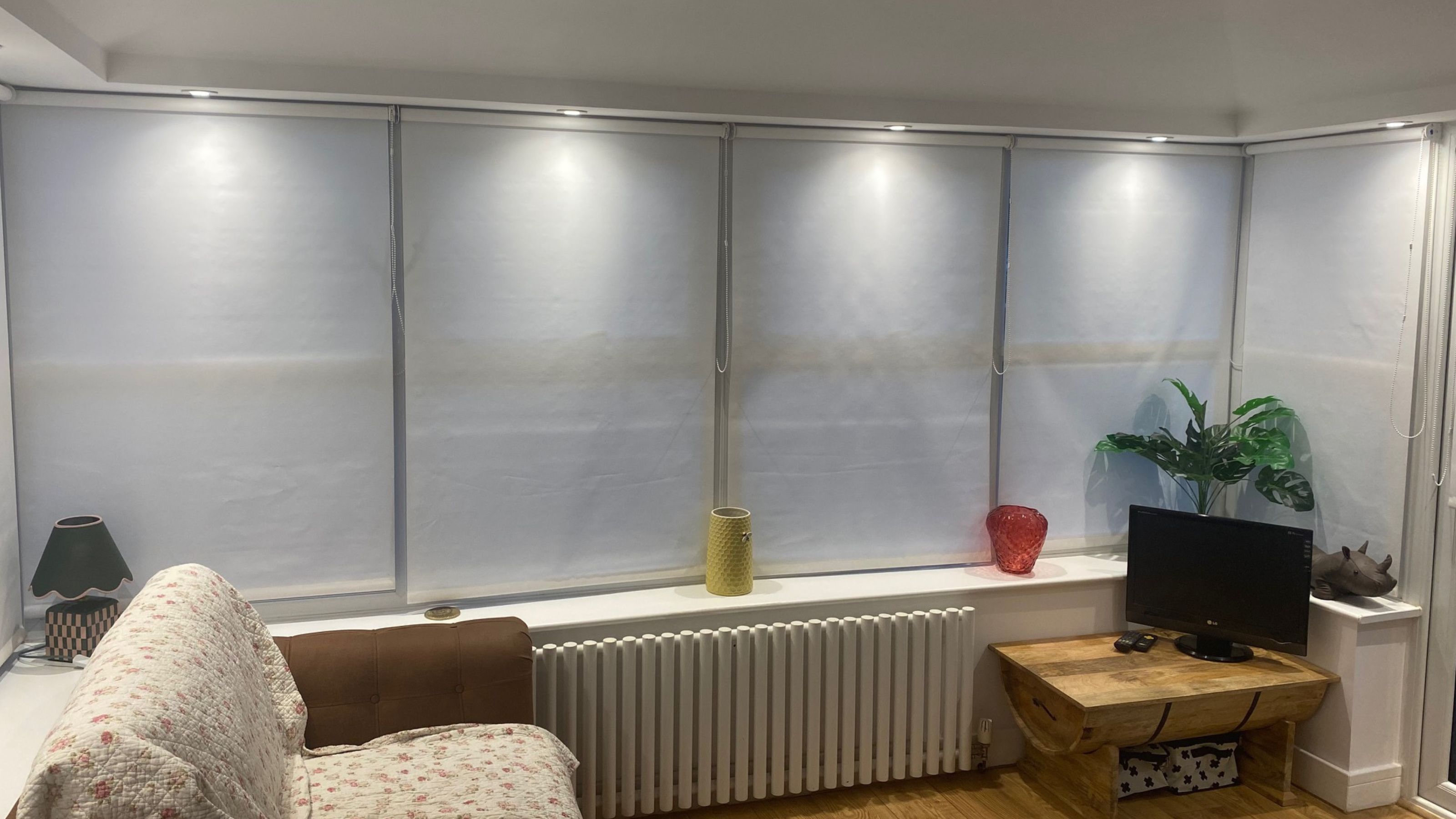 The finished conservatory room, with pelmet spotlights, blinds, chair coffee table and small TV