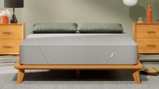 The Siena Memory Foam Mattress on a bed frame in a bedroom, with pillows on top