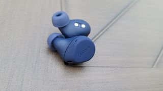 The Jabra Elite 7 Active earbuds resting on a wooden table