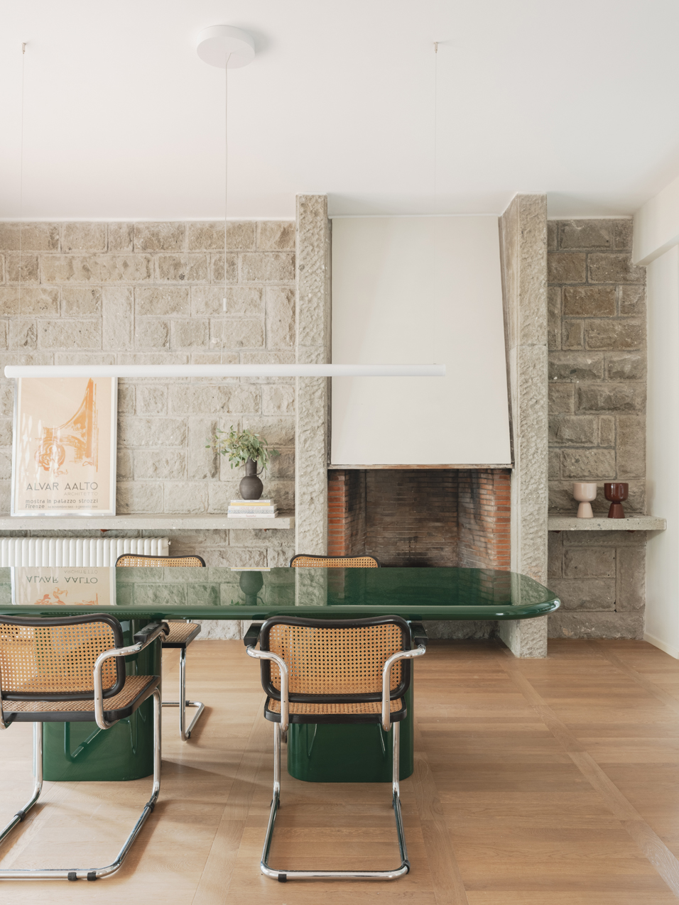 a dining room with a green lacquer table and stonework walls