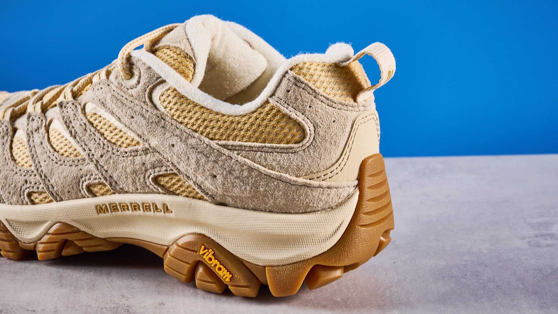 the merrell moab 3 photographed against a blue tom's guide background