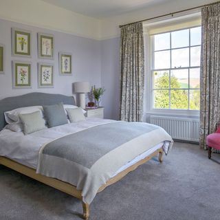 bedroom with grey wall with picture frames and double bed