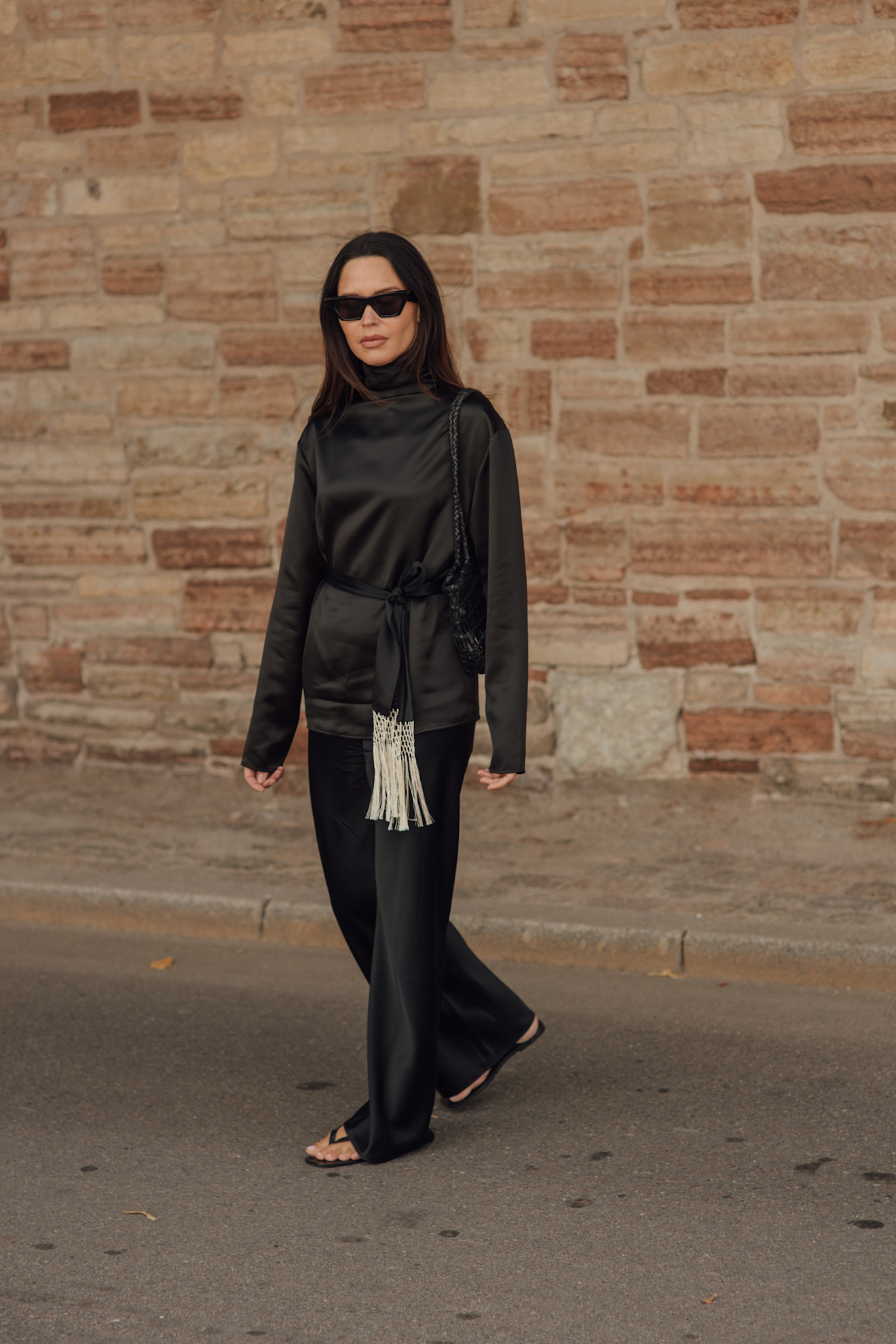 a street style shot of a woman in all black