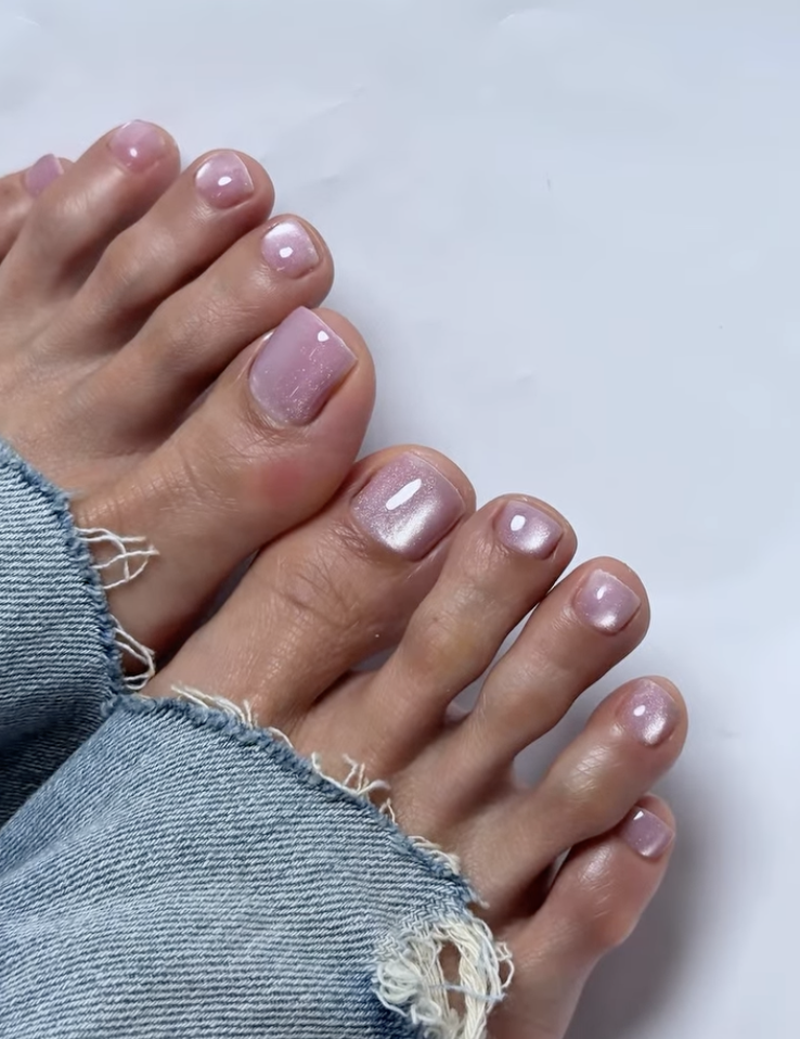 pink glossy toes on a girl wearing jeans