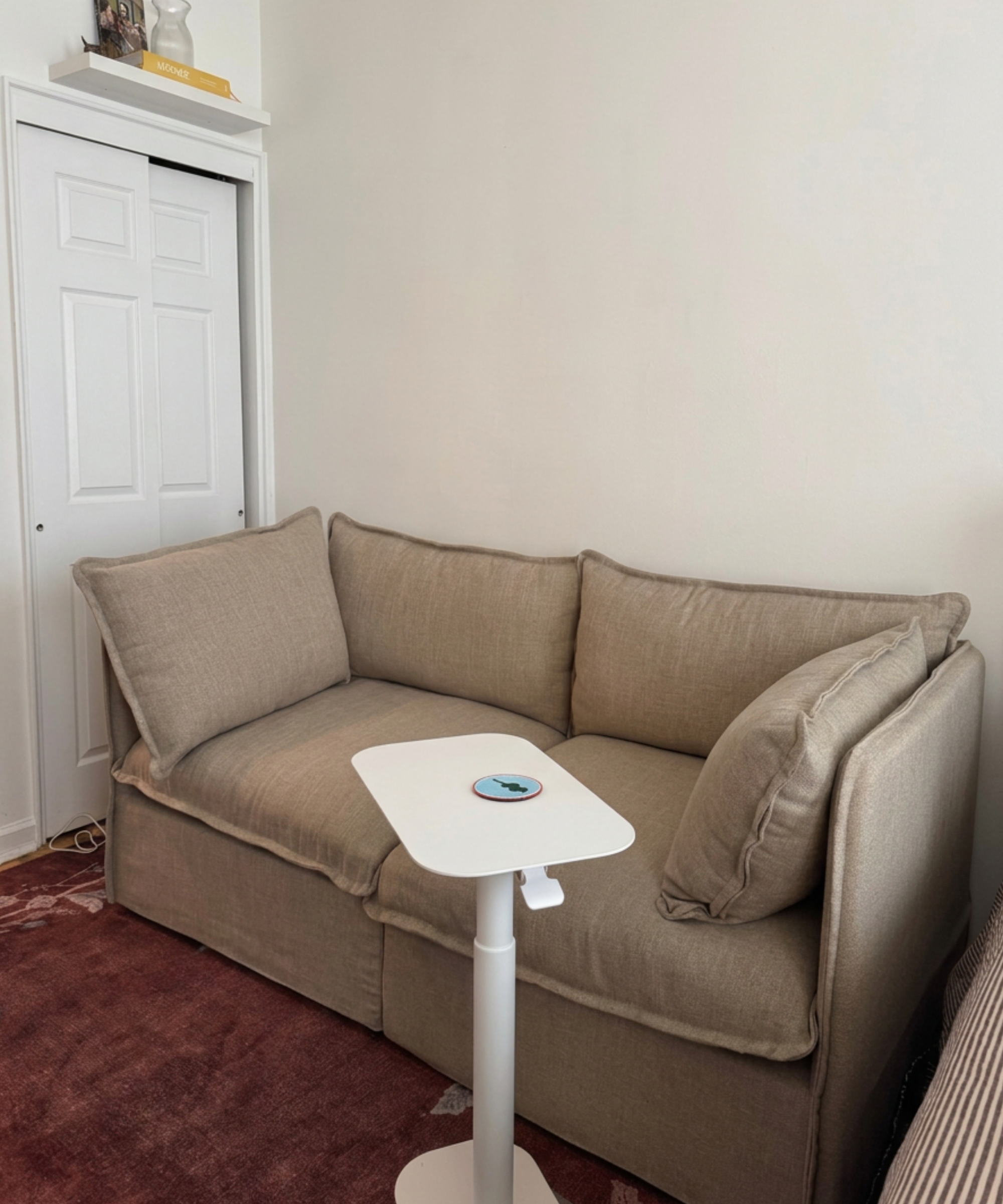 a tan couch with a white adjustable table