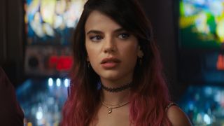 Sonia Ammar stands in front of pinball machines with a suspicious look in Scream (2022).