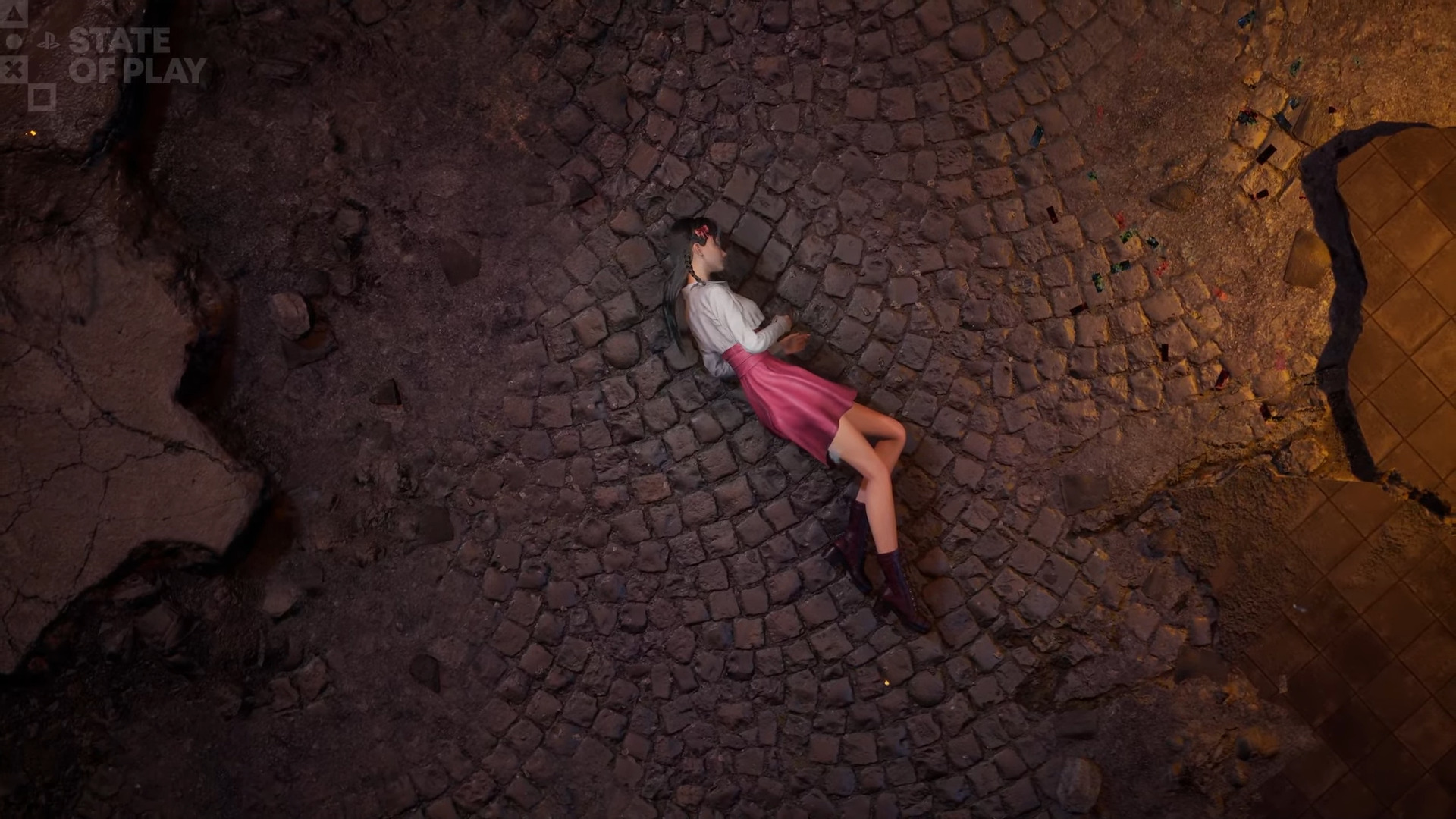 A woman lying on a cobblestone street