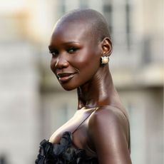 Adot Gak on the streets of Paris wearing one of the best blushers for dark skin tones