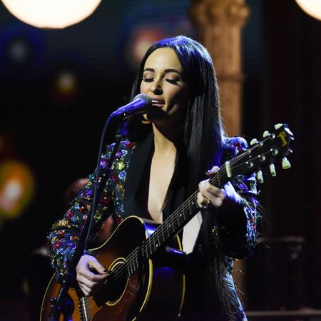 Kacey Musgraves performs onstage with her guitar