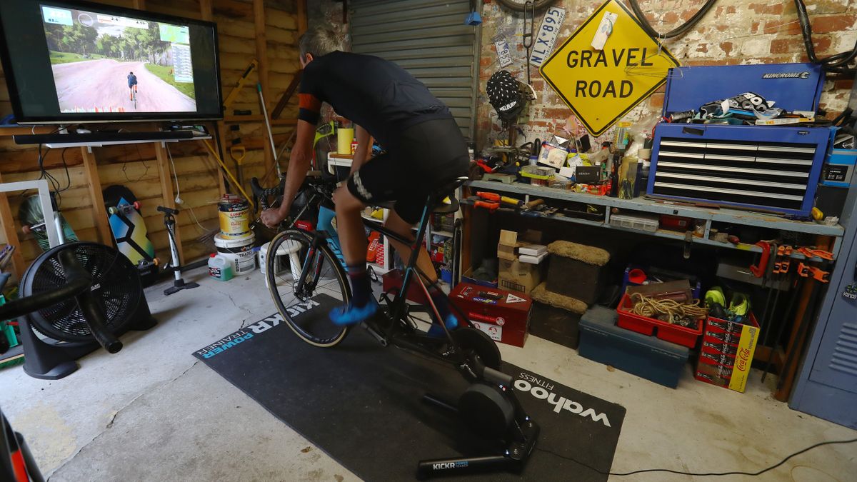 A man riding on a smart trainer in a garage 