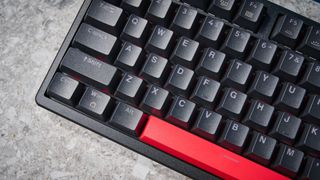 A black Lemokey X5 wired mechanical keyboard with red and black keycaps