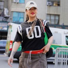 Rihanna wears a baseball hat and a black sports jersey in New York City