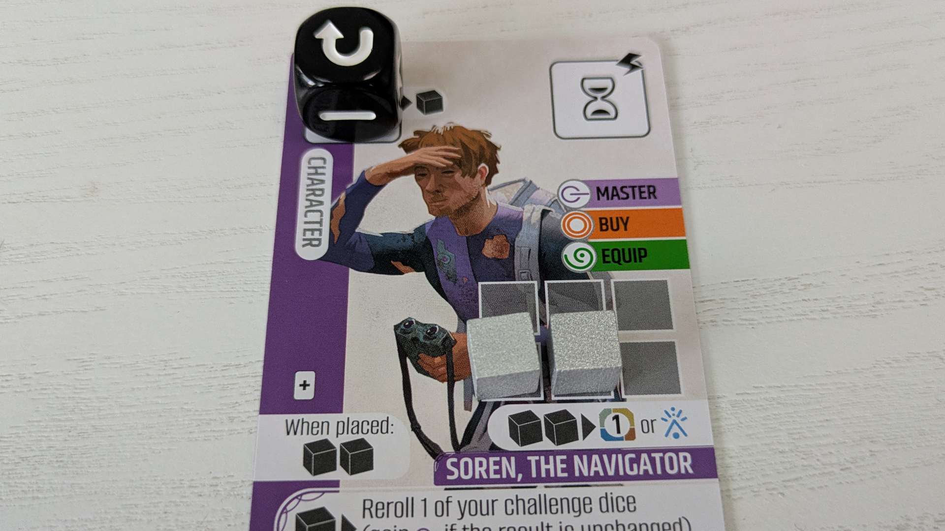 A card for &#039;Soren, the Navigator&#039; with a die and tokens on it, placed on a white wooden surface