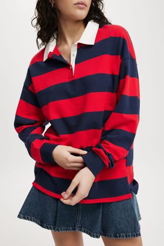 a model wears a red and navy blue striped polo shirt