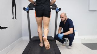 Podiatrist analyzing runner's gait using treadmill