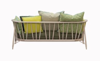 A wooden framed sofa with different colour cushions on it.