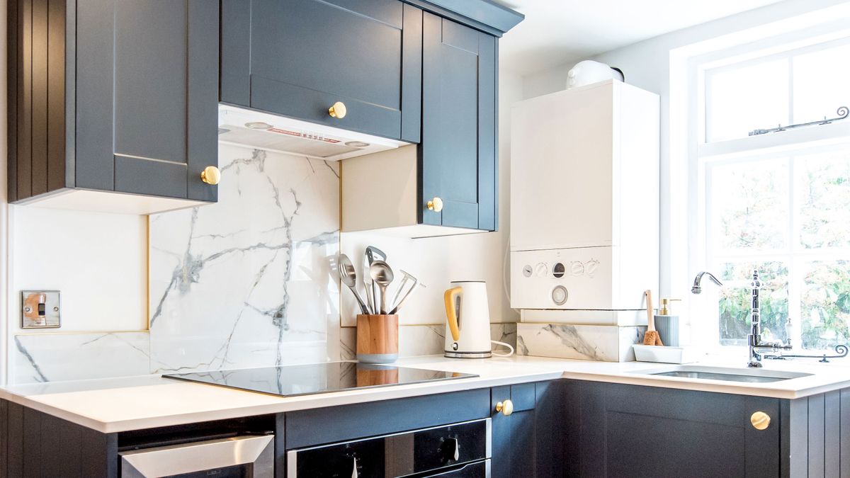 Dark blue and white kitchen with white combi boiler on waller