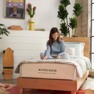 A child sat on the Avocado Eco Organic Kids' Mattress.