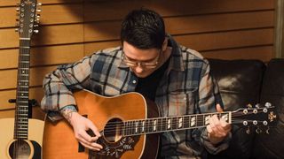 Customer trying an acoustic guitar in a guitar store