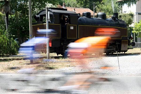 Riders wizz past a steam train