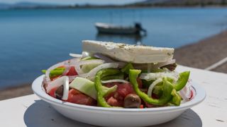 A Greek salad in front of a Lesvos fishing village