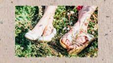 two women's feet in sunny grass, one with white ballet pumps on and one with white sandals