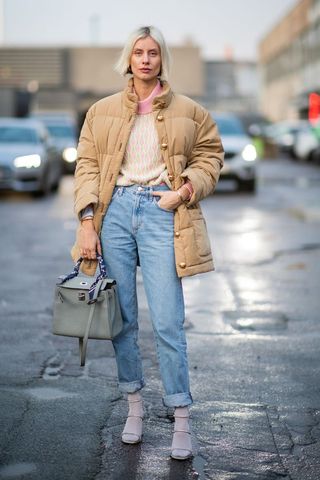 a street style influencer wearing a padded jacket with straight leg jeans