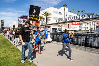 WGA and SAG-AFTRA members strike in front of the Fox backlot.