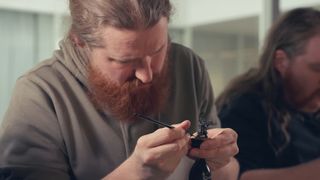 Man painting a Warhammer miniature