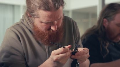 Man painting a Warhammer miniature