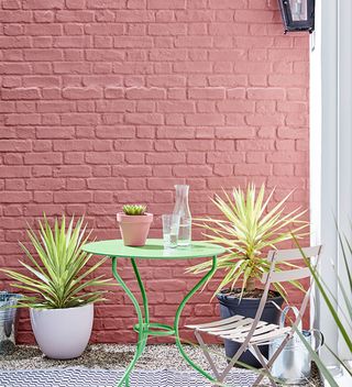 How to paint an exterior wall with red brickwork and table and chair