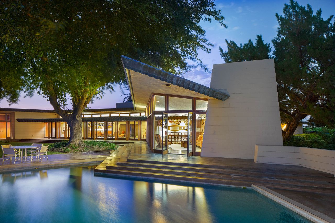 An exterior view of an property with a pool and large windows