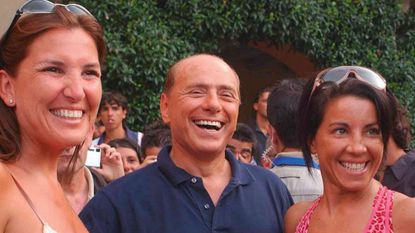 Silvio Berlusconi is photographed with two unidentified women 