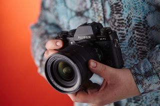 Detail of a photographer holding a Fujifilm X-T1 compact system digital camera