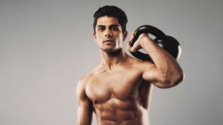 a photo of a strong man holding a kettlebell