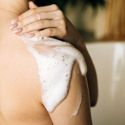 Best body washes - woman with lather all over her back in the shower - gettyimages 1455794520