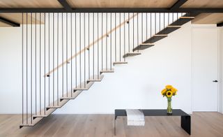 The stairway treads are suspended from the frame of the house by rods