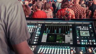 A sound engineer using the SSL Live console at a aconcert.