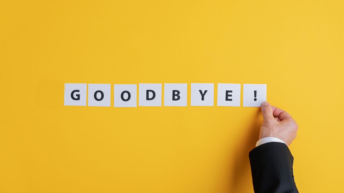 A businessman&amp;#039;s hand placing white squares with black lettering spelling out &amp;quot;Goodbye!&amp;quot; on a yellow background